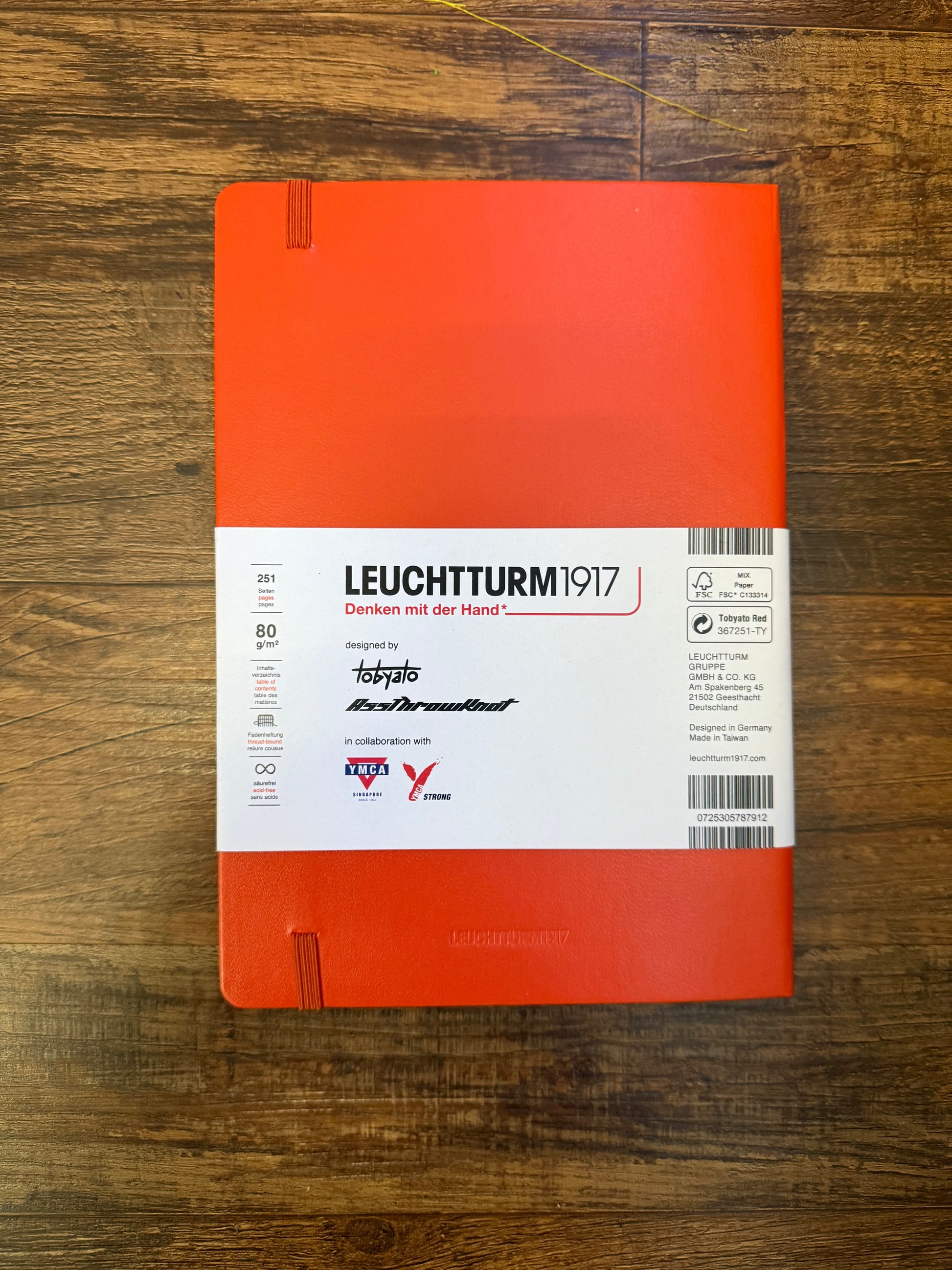 Leuchtturm1917 Tobyato Edition A5 Medium Notebook in fox red with dotted pages, featuring a cover design of a raven with books and typewriter keys, symbolizing knowledge and resilience.