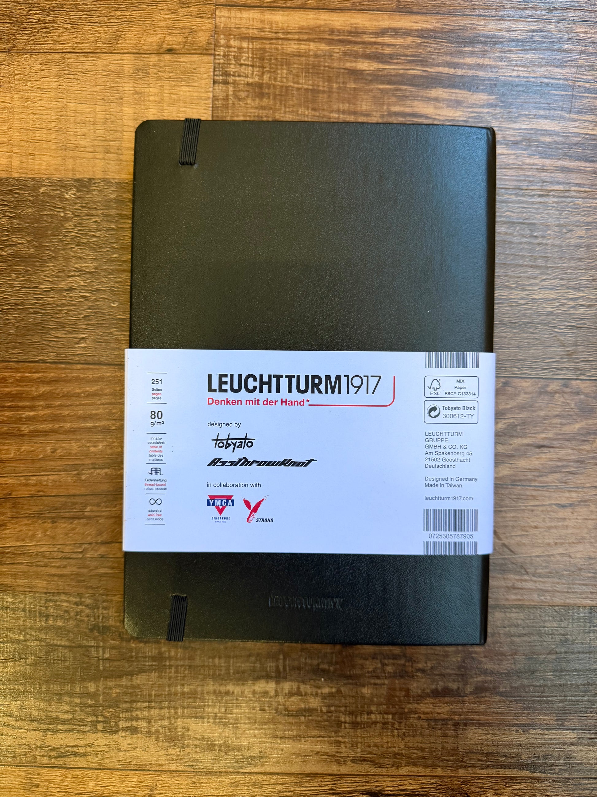 Leuchtturm1917 Tobyato Edition A5 Medium Notebook in black with ruled pages, featuring a cover design of a raven surrounded by books and typewriter keys, symbolizing creativity and knowledge.